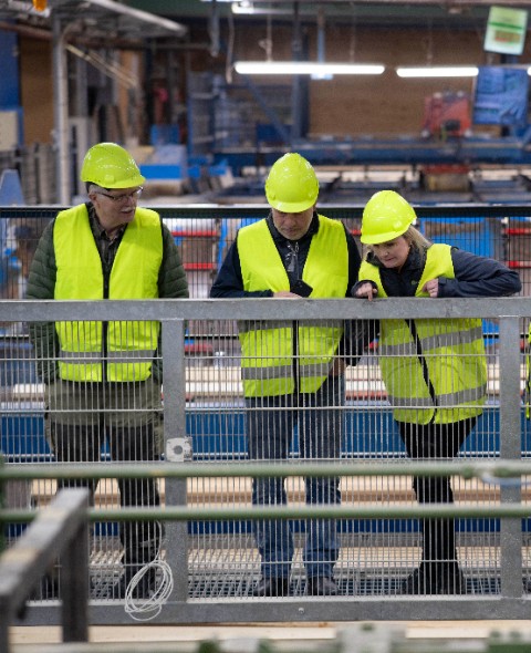 Tre personer tittar ner på sågverket i Gällö